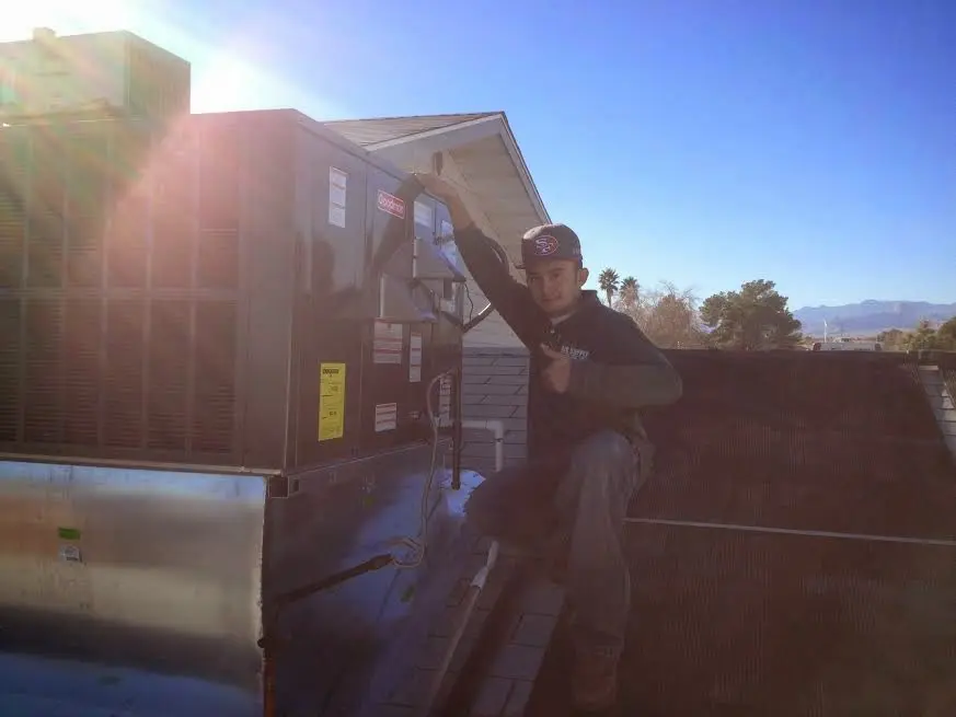 HVAC technician performing AC Tune-Up on a rooftop unit in Holly Springs